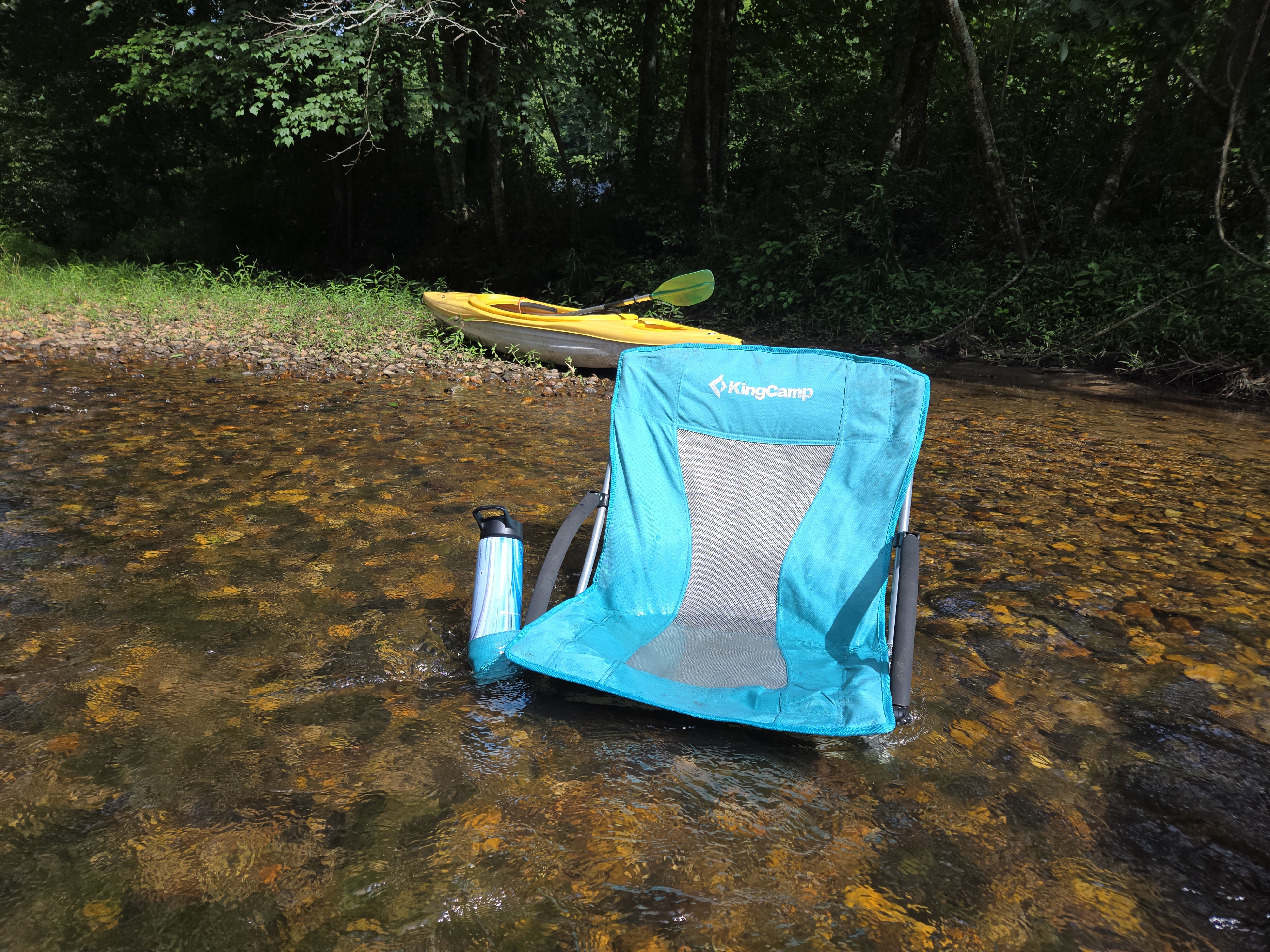 Camp chair in the Toccoa River with a kayak on the bank in North Georgia